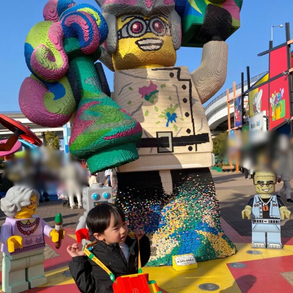 レゴランドのレゴブロックの前でポップコーンを持つ4歳の子供