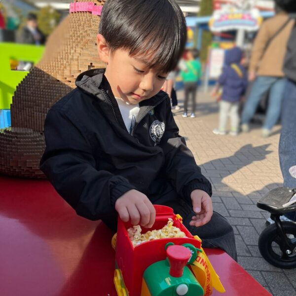 レゴランドのポップコーンをポップコーンバケツを楽しみながら食べる4歳の子供